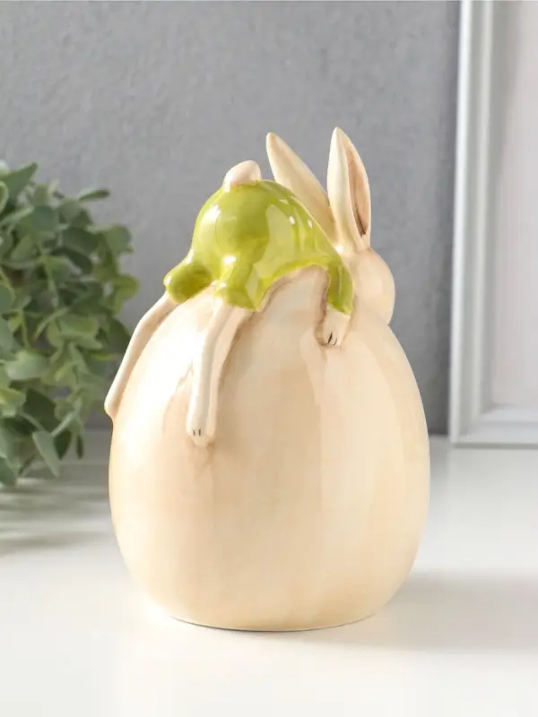 Сувенир керамика "Зайчик в зелёном костюме, лежит на яйце" 10,4х10х14,9 см