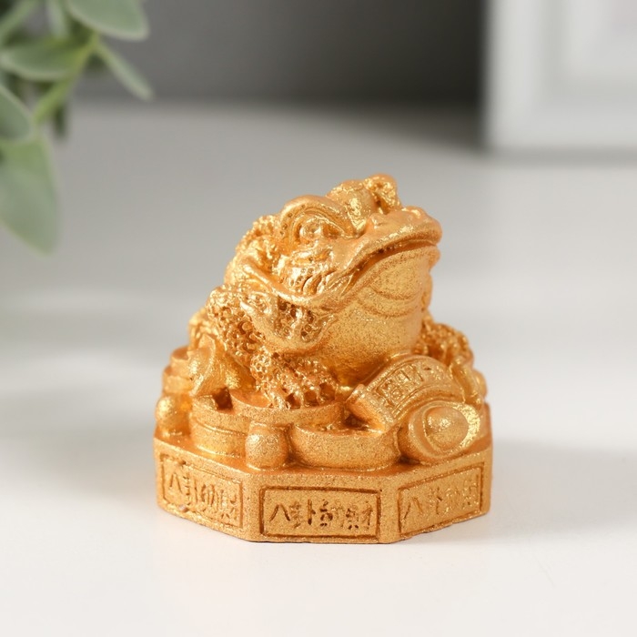 Нэцкэ полистоун под золото  Нэцкэ полистоун под золото "Жаба на монетках и пьедестале с символами" 4,2х4,4х4,1 см