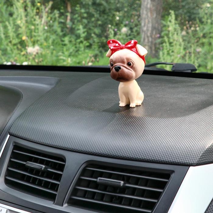 Собака на панель авто, качающая головой, мопс Собака на панель авто, качающая головой, мопс